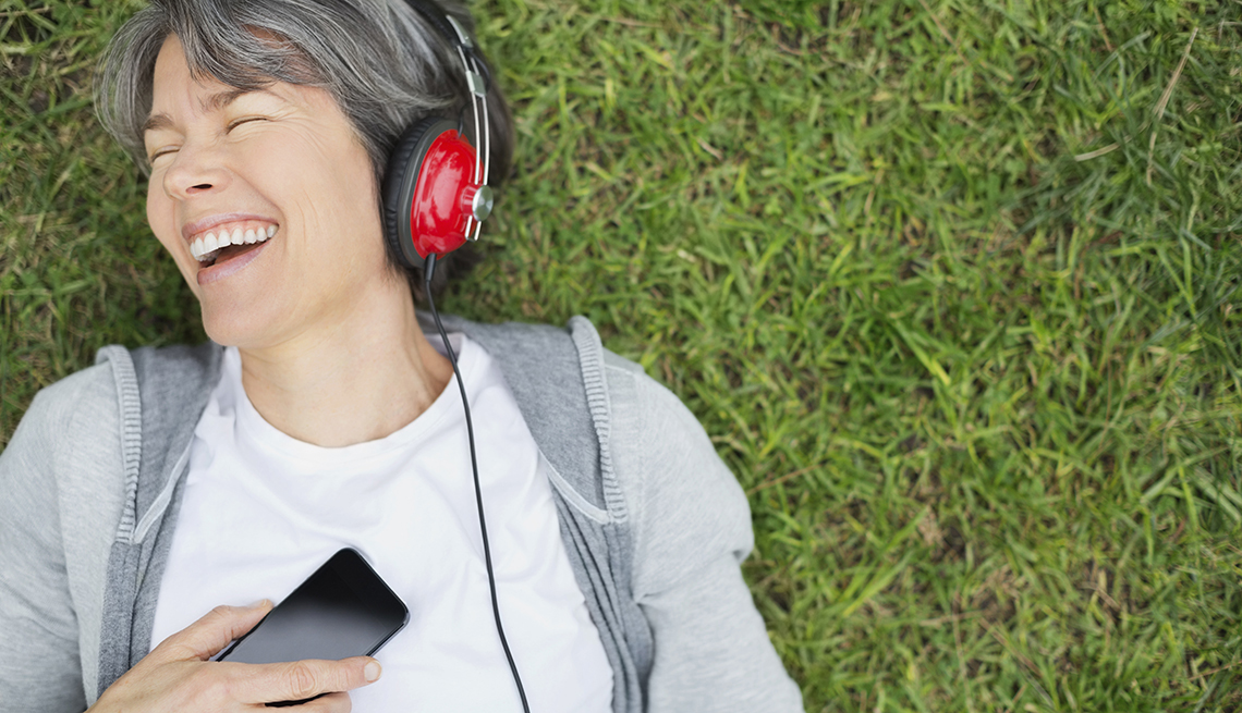 Happy woman listening to music at park