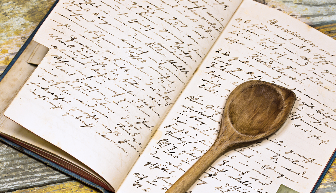Libro de recetas escrito a mano con una cuchara de palo encima