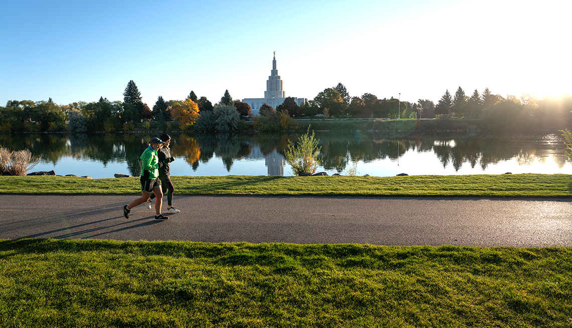 people jog along a path next to the snake river in idaho falls idaho on a pretty day