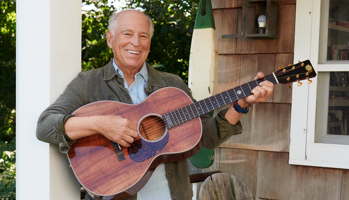 Jimmy Buffet sostiene una guitarra en su casa en Sag Harbor, Nueva York