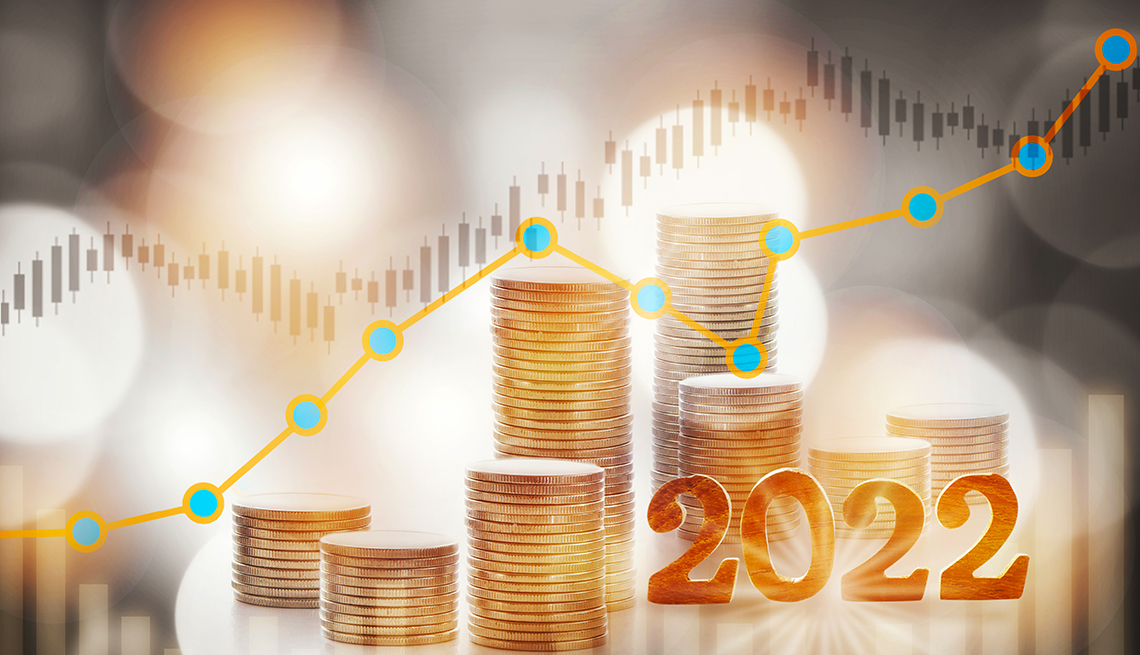 Monedas apiladas sobre unas gráficas estadísticas y el año 2022
