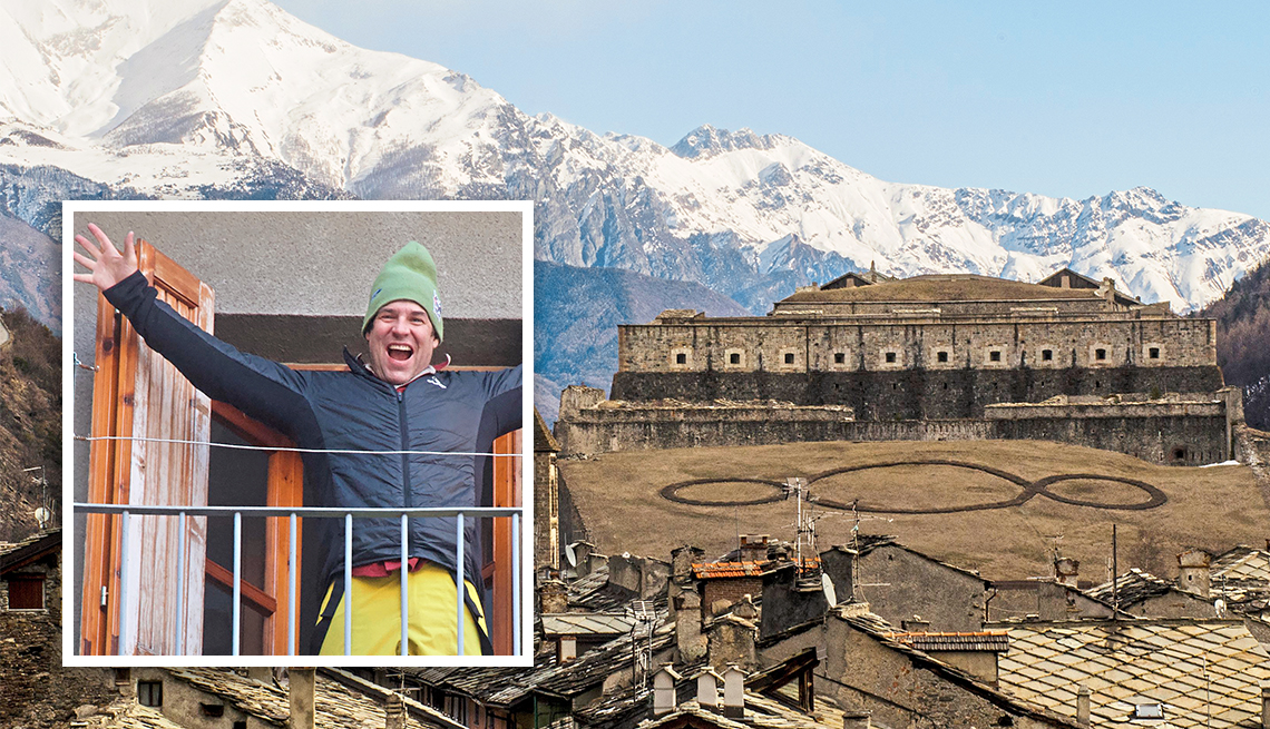 town in the italian alps with an inset of tom winter standing on the balcony of his home there
