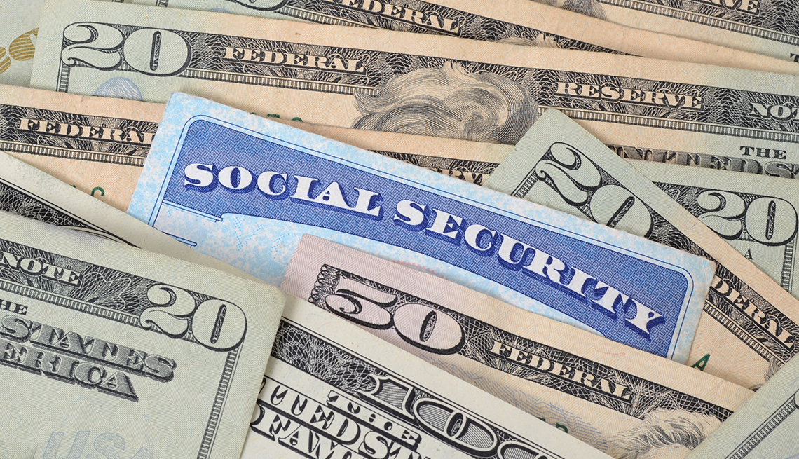 Tarjeta del Seguro Social en medio de billetes de $20 dólares.