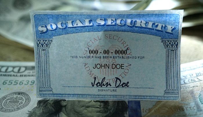 close up photo of a social security card over U.S. currency
