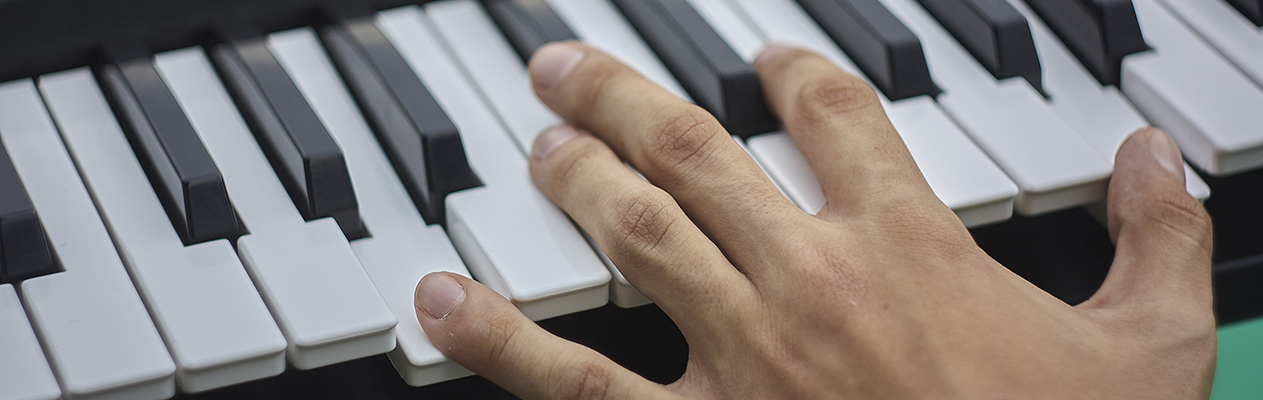Hand on piano keyboard