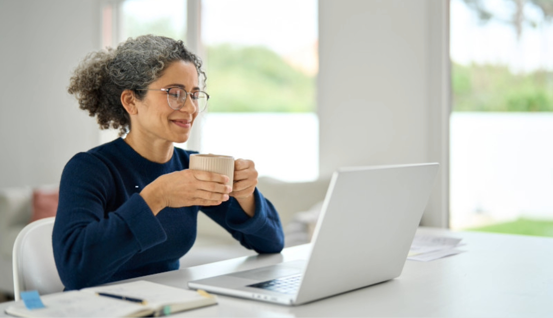 Woman on laptop with a drink