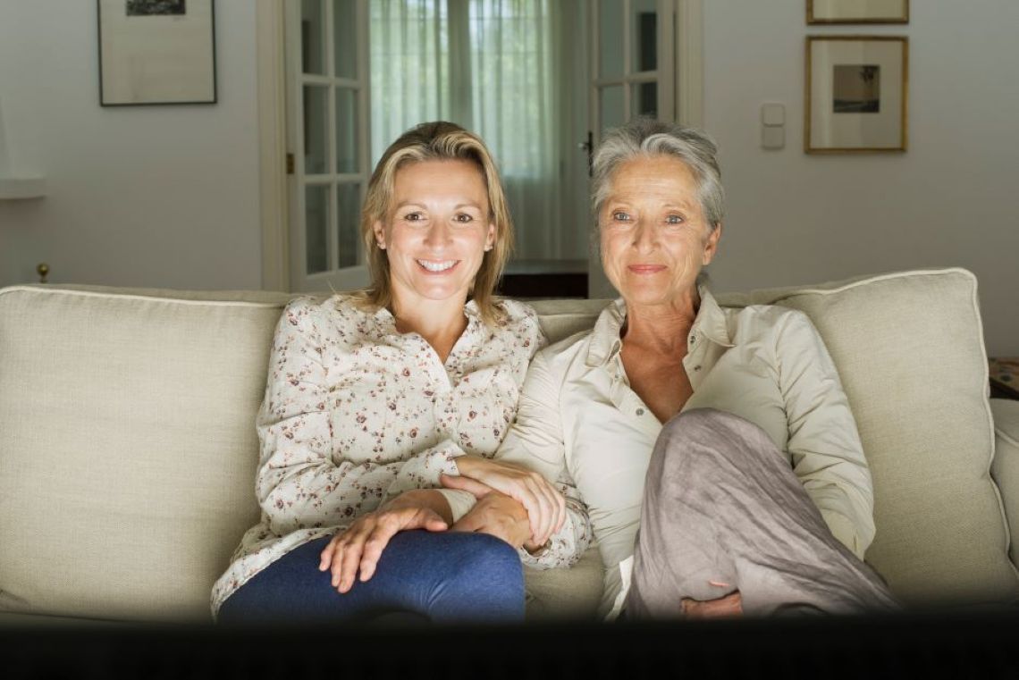 Mother daughter on sofa watching TV