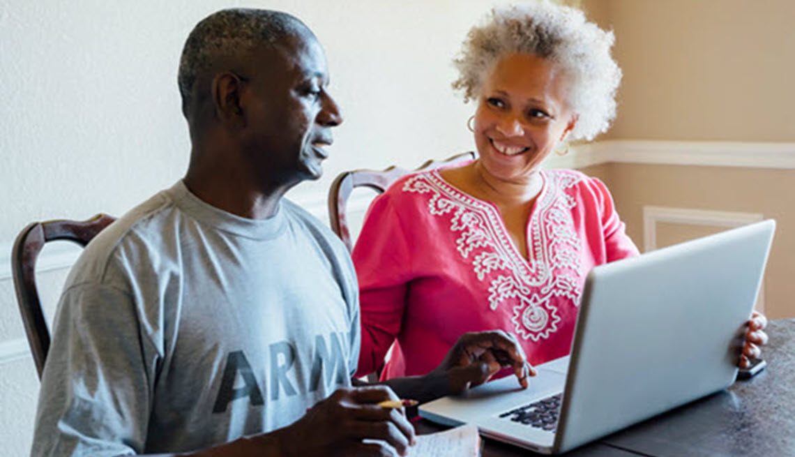 Veteran couple at table discussing finances.