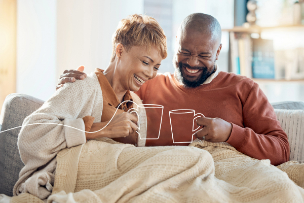 Couple Sitting on Sofa Drinking Coffee