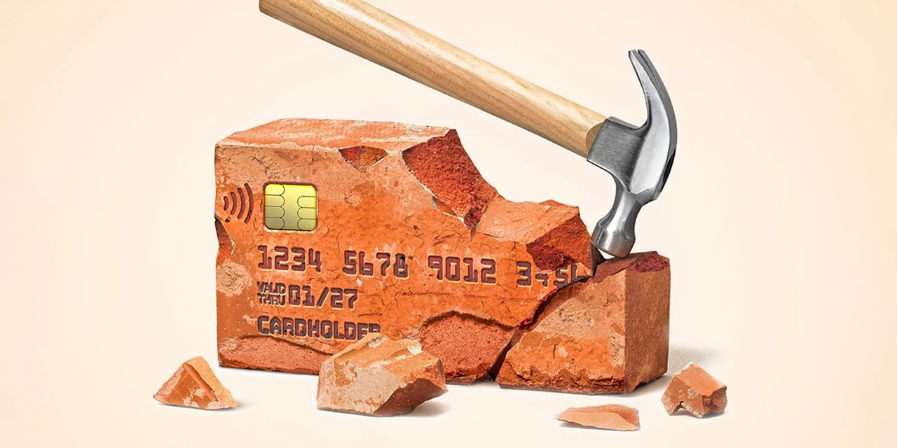 Hammer breaking a brick resembling a credit card.