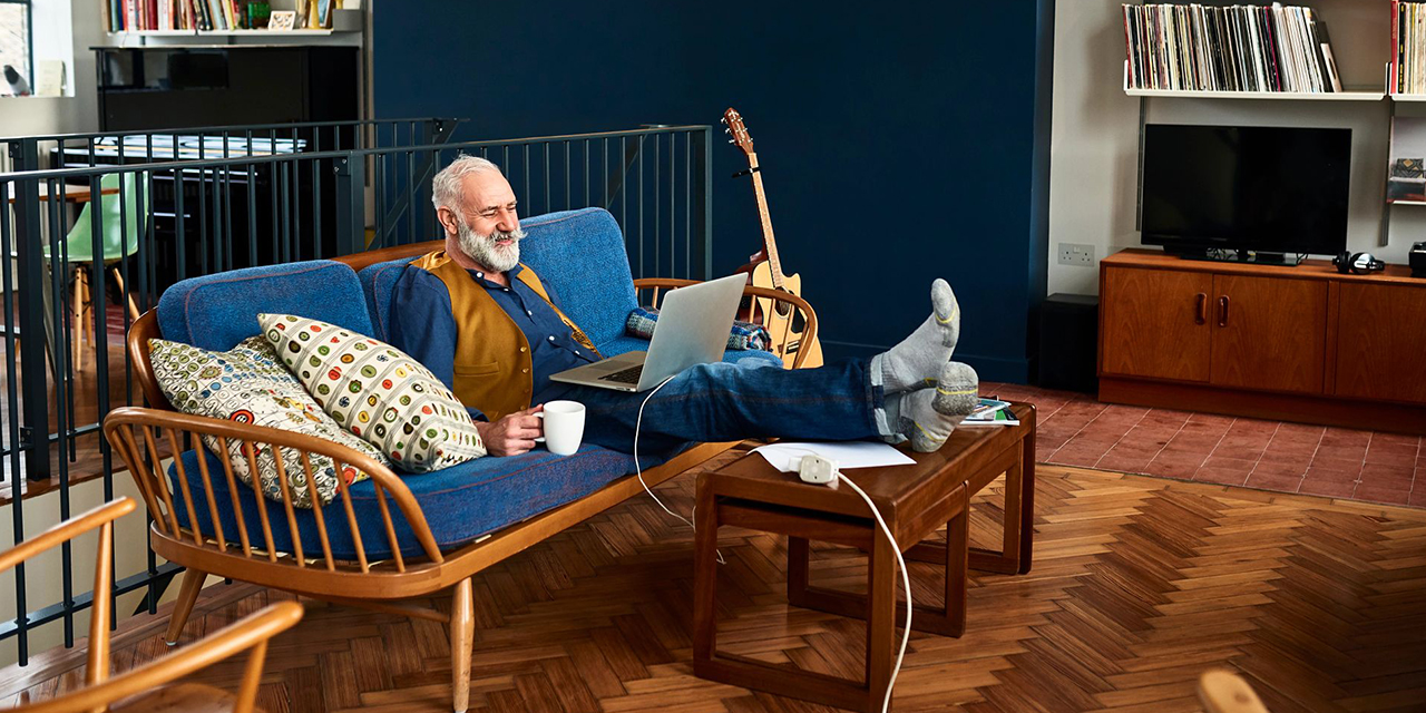 Person using a laptop in their living room.