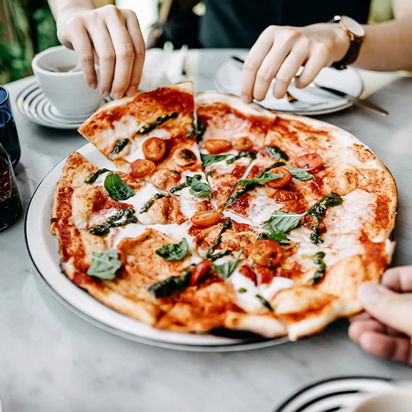 closeup of pizza being shared by two people