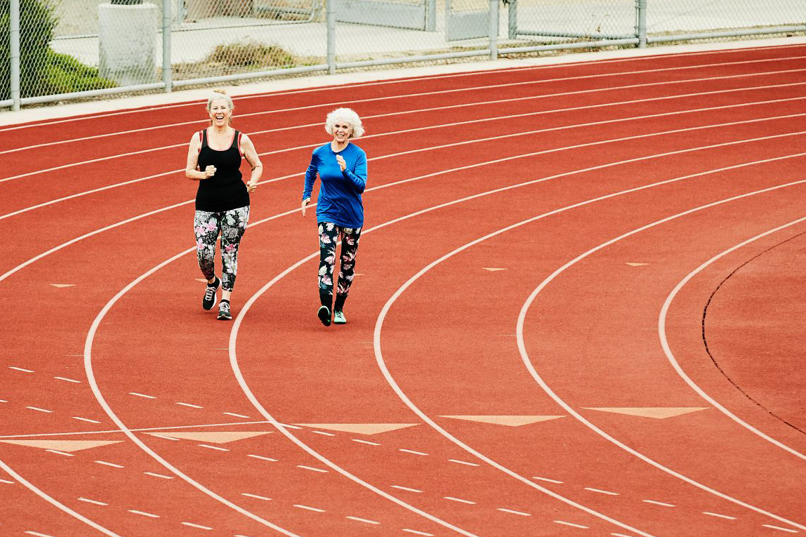 two women walking around a track