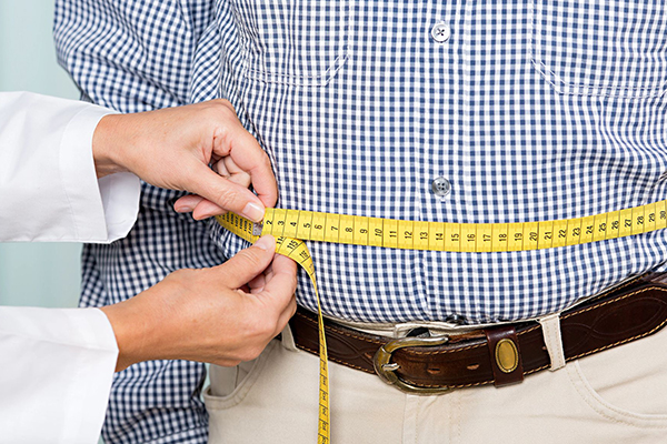 doctor measures patient waist