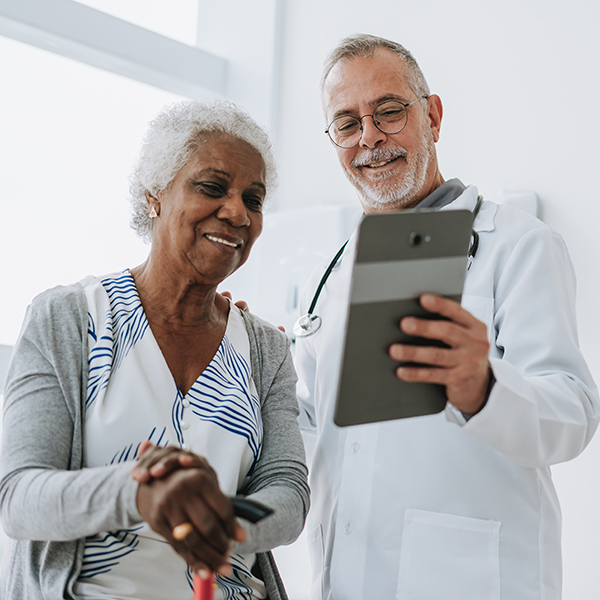 Doctor attending senior patient using digital tablet