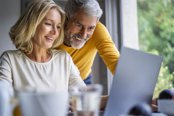 Happy couple using laptop.