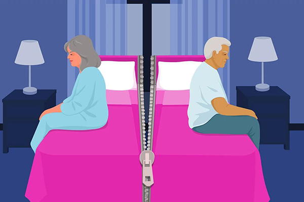 Couple sitting on opposite sides of a bed.