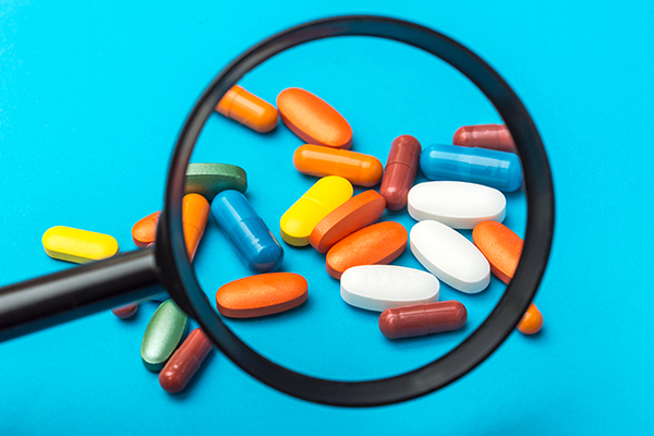 Pills under a magnifying glass.