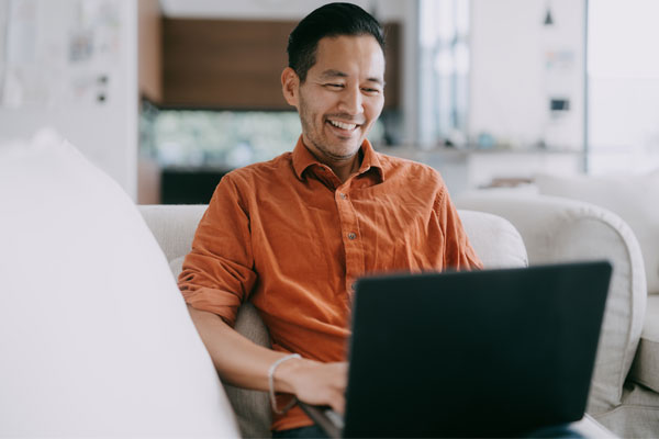 Person smiling while using their laptop.