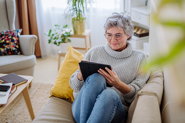Person using a tablet on a couch.