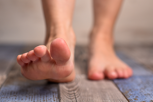 Barefoot person stepping forward.
