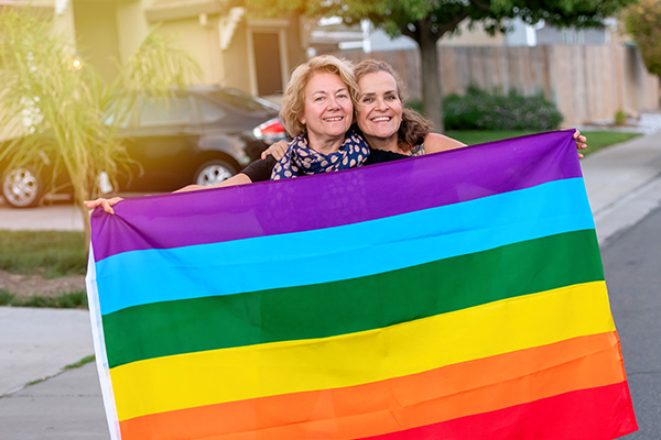 People holding a Pride flag.