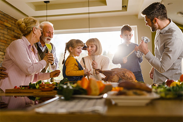 Family standing around a dining table. 