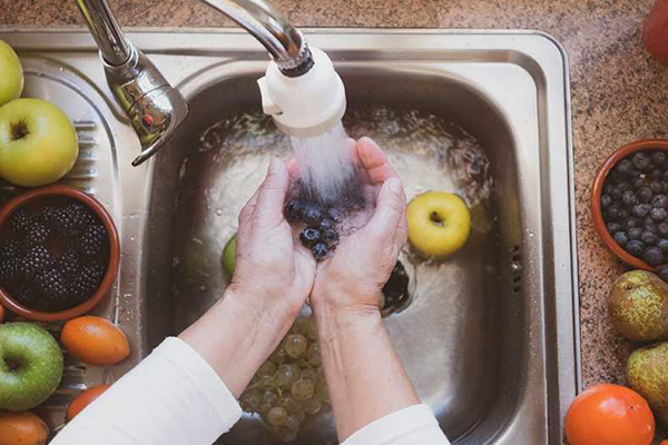 Person rinsing fruit.