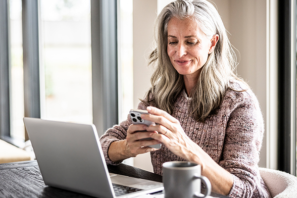 Person using a smartphone and laptop.