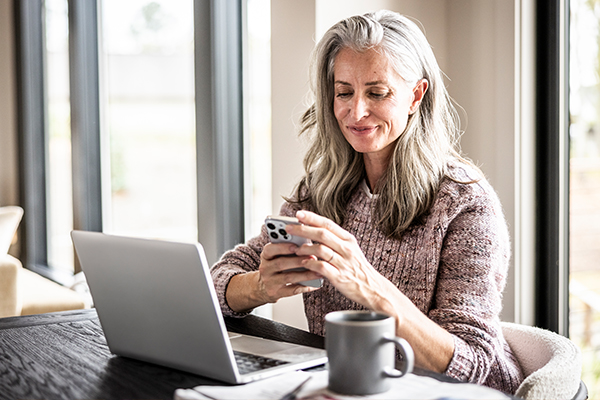 Person using a smartphone while seated at a table.