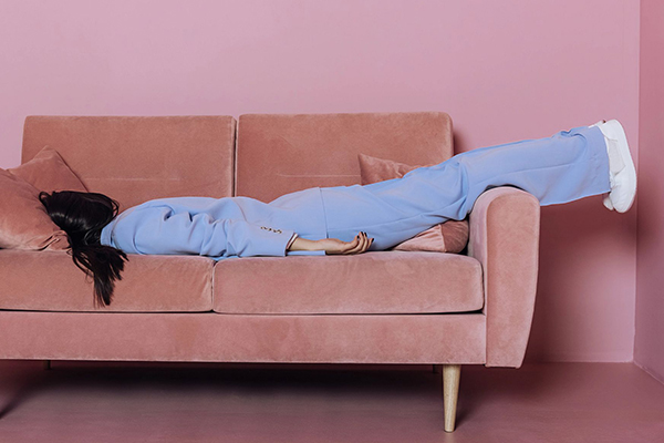 Person lying face down on a couch.