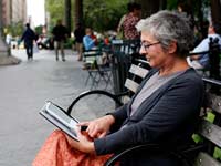 woman reading an e-book in the park