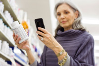 five ways to save money with smartphone mature woman shopping in store with smartphone