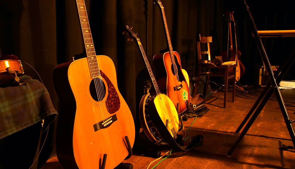 Instrumentos musicales de cuerda puestos sobre el piso de un escenario.