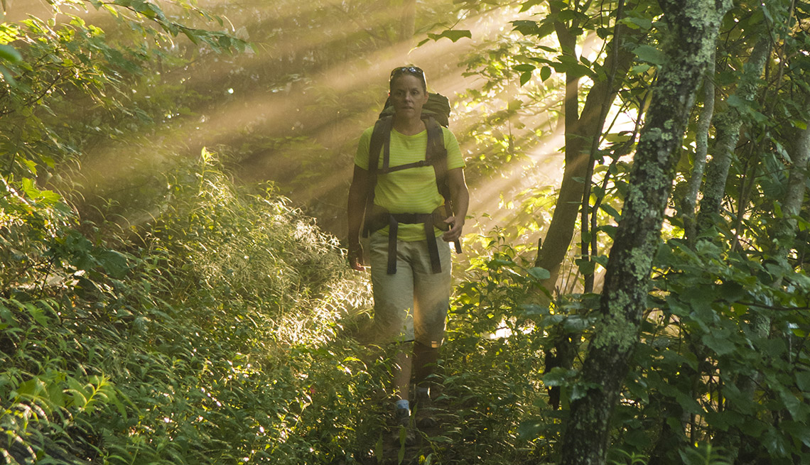 Mujer excursionista camina por el bosque nacional Pisgah.