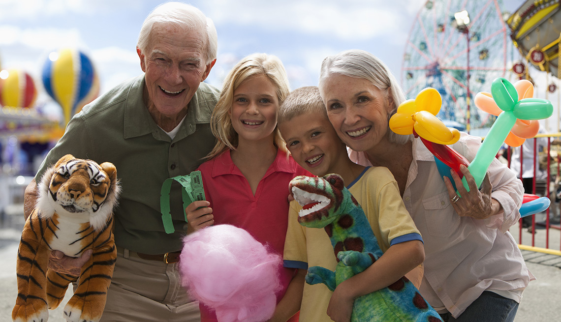grandparents with grandkids smiling at an amusement park