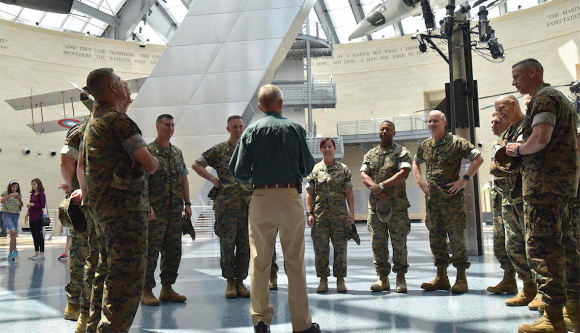 Docent surrounded by Marines at the National Museum of Marine Corps