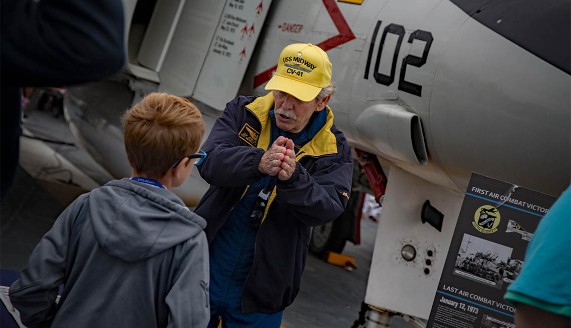 Voluntario habla con un visitante del USS Midway 