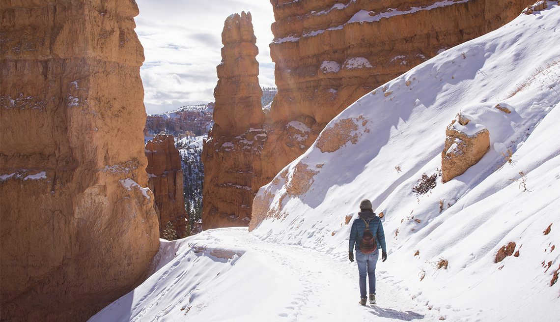 female hiker walking on a trail in Bryce Canyon National Park during winter