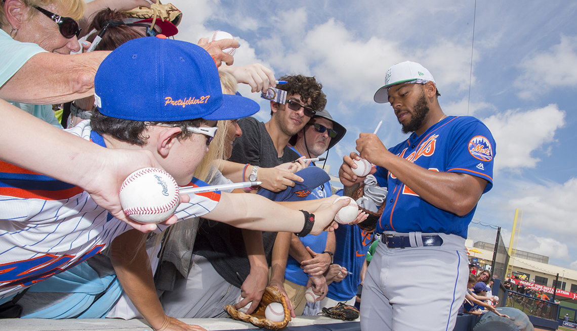 A New York Mets player signs autographs for fans at spring training
