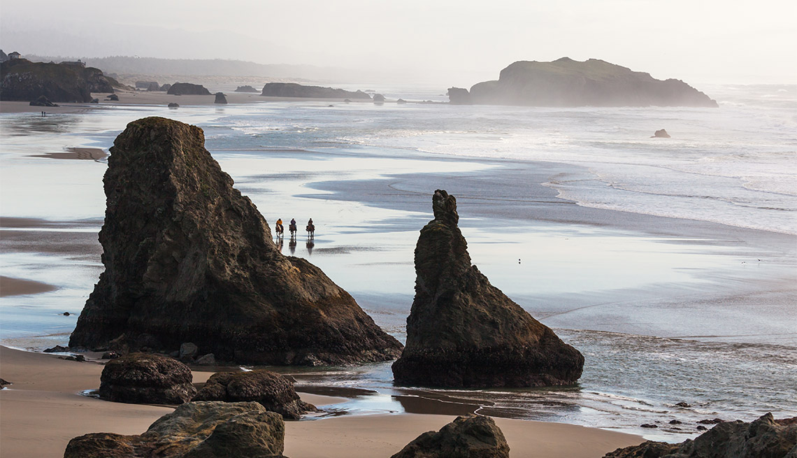item 8 of Gallery image - three people touring the beautiful beach in Bandon Oregon on horses
