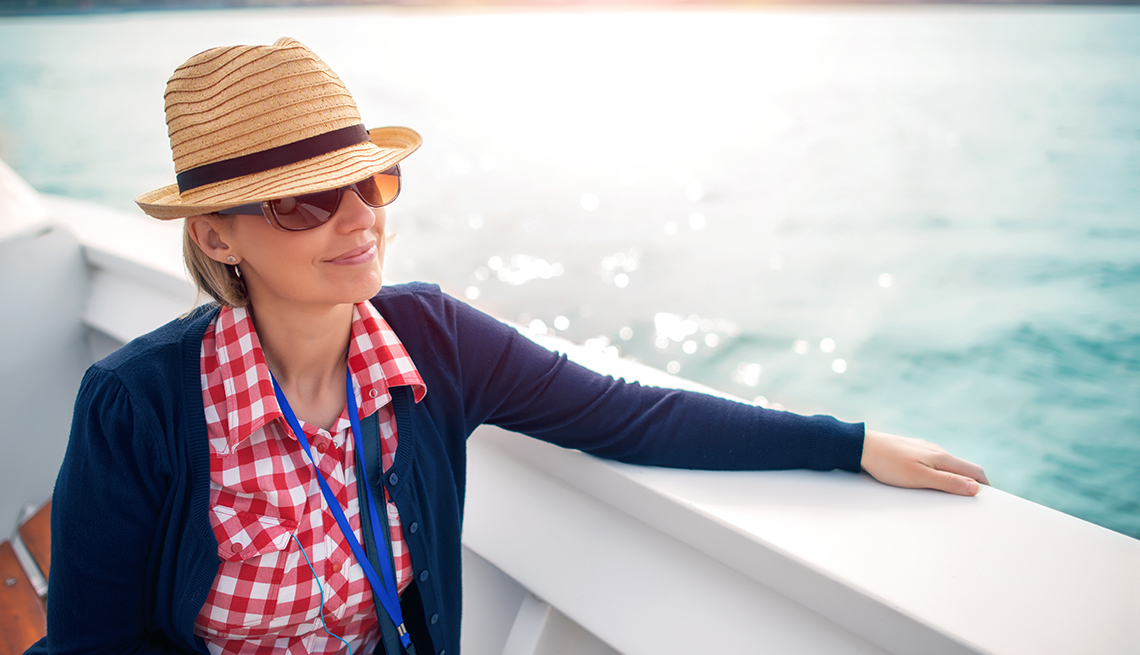 Una mujer observa el mar desde la cubierta de un crucero.
