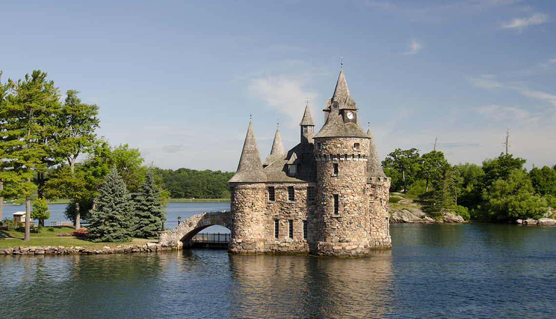 a castle standing at the end of a causeway in a river