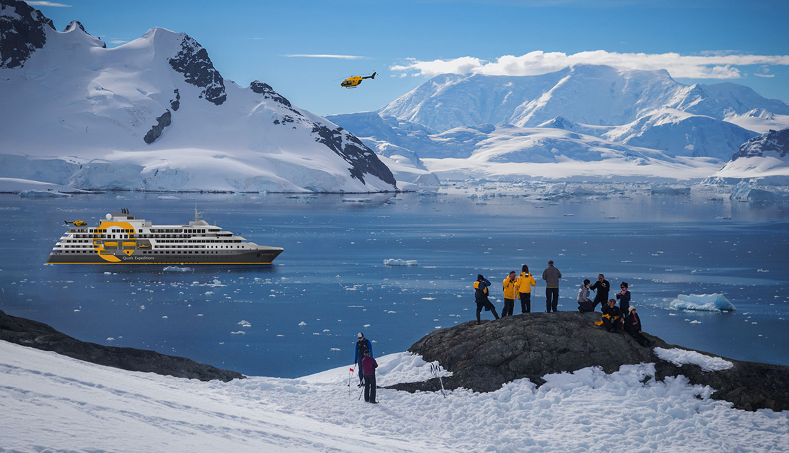 as group of passengers stands on land after being dropped off by a helicopter for an excursion from their cruise ship in the antarctic 