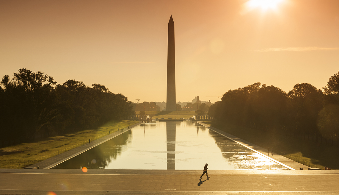 dusk view of the washington monument and reflecting pool with jogger in foreground