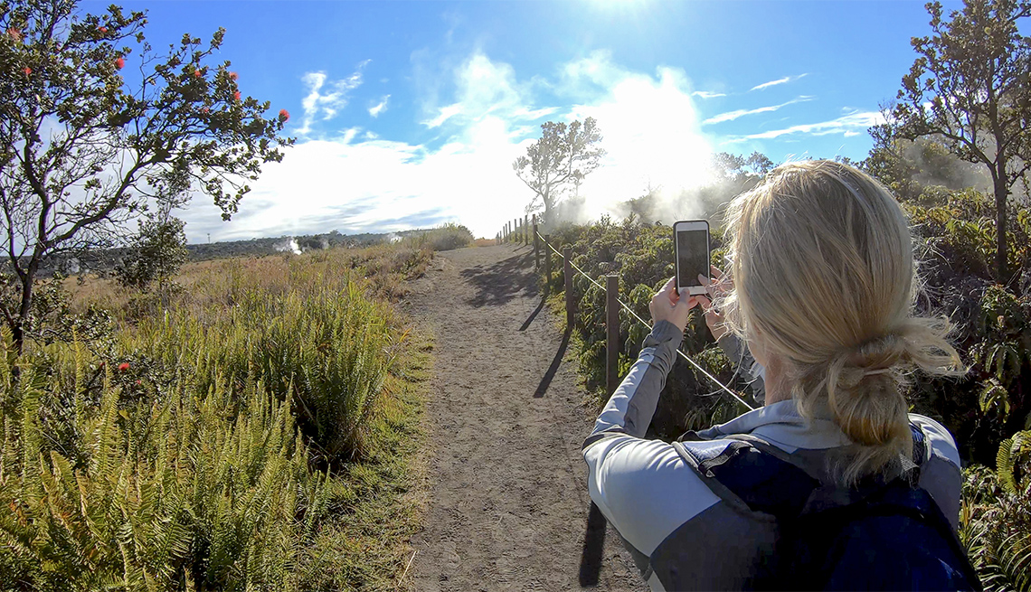Female hiker takes a photo while on Crater Rim Trail
