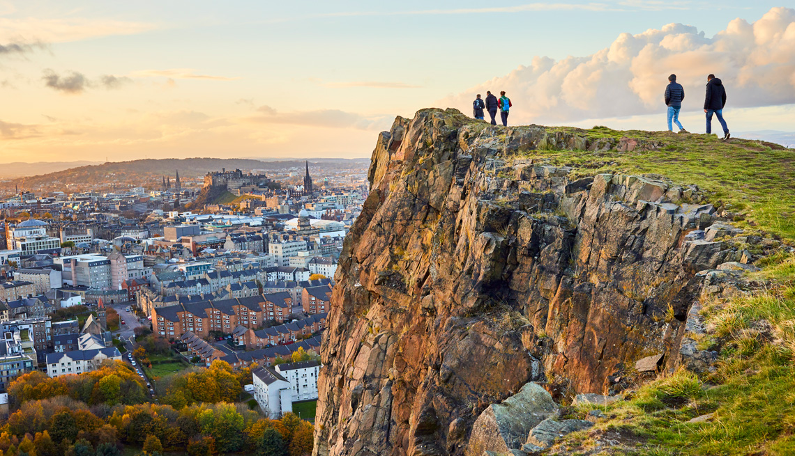 Personas observan un acantilado con vista a Edimburgo, Escocia