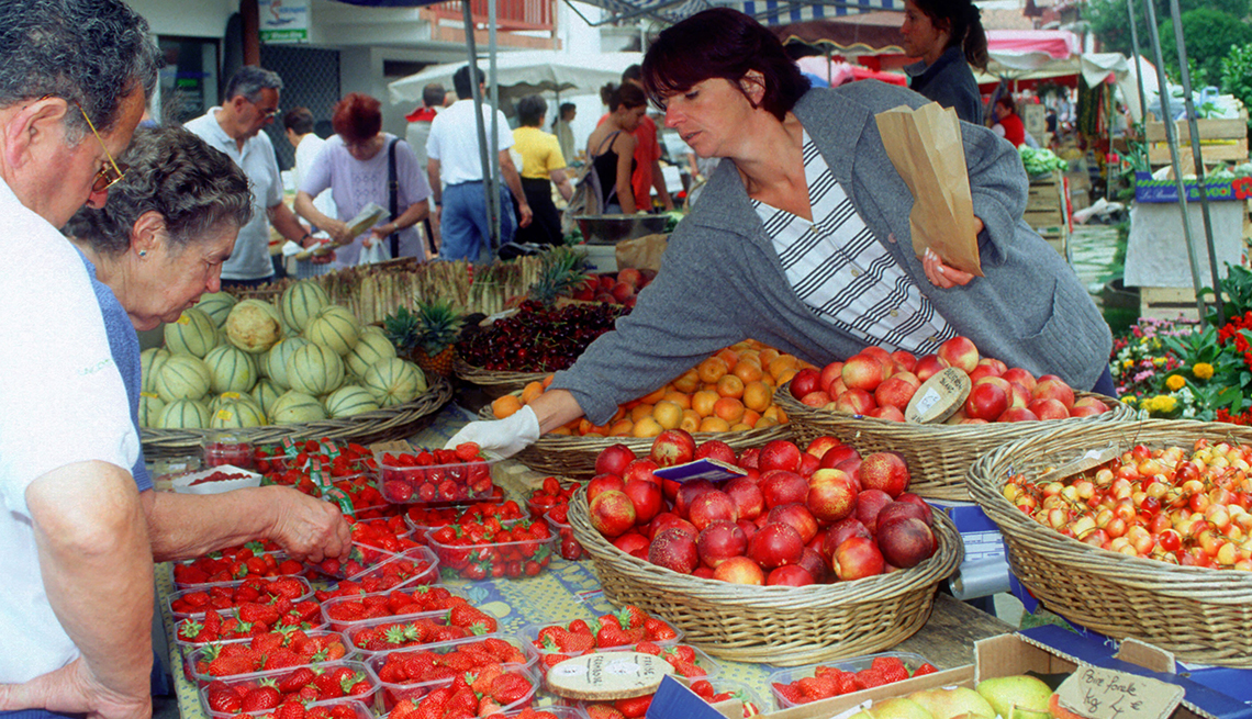 Los compradores seleccionan fresas frescas en un puesto de frutas en el mercado de Les Halles.