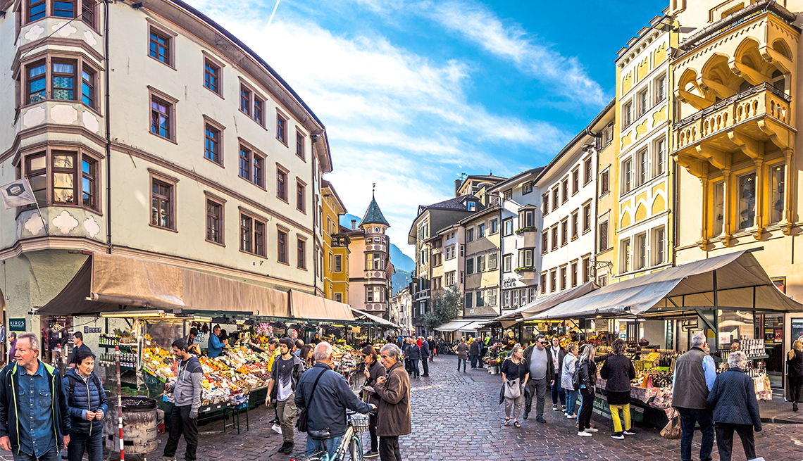Gente de compras en una famosa plaza del mercado en el casco antiguo de Bolzano, Italia