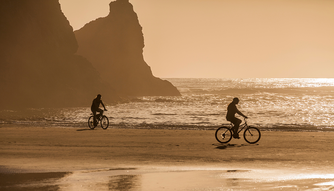 Couple Riding on Beach, Sunset Rocks, Gold Light, Budget-Friendly Travel Ideas